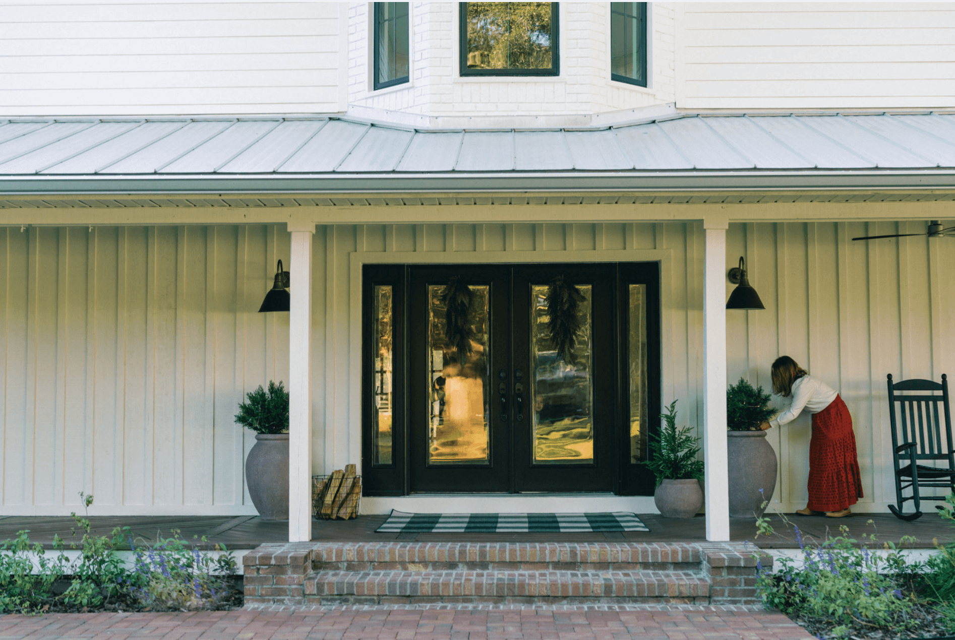 a front entry with rustic planters and an outdoor rug